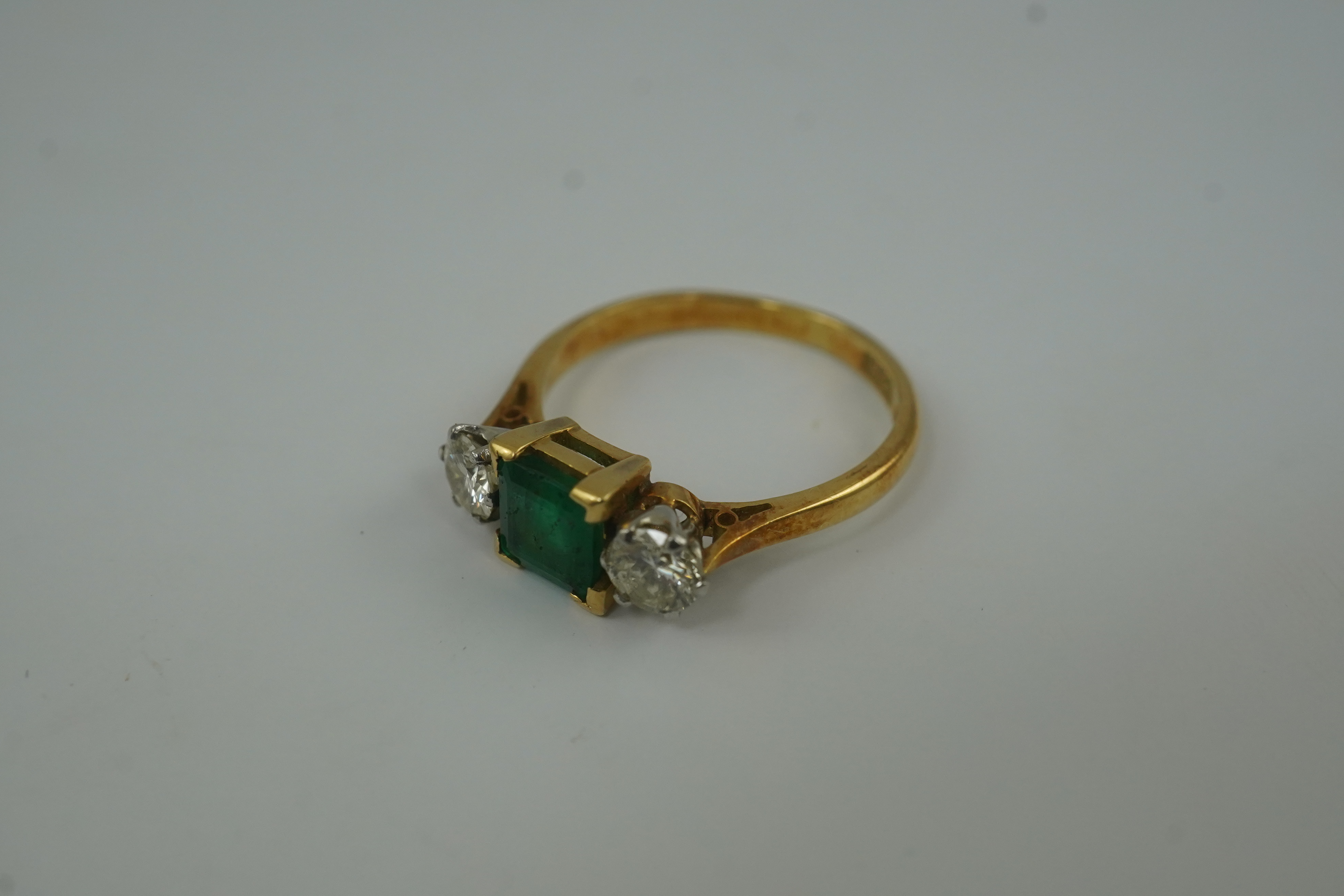 A mid 20th century 18ct gold and platinum, single stone emerald and two stone diamond set ring